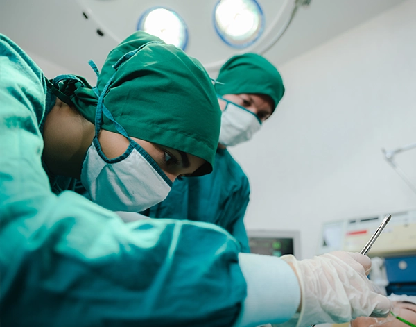 Three professional cleaners in bright green overalls standing confidently with cleaning equipment in modern home interior with gray walls