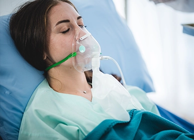 Three professional cleaners in green and red overalls working in a modern kitchen, mopping the floor, and cleaning high walls and windows.