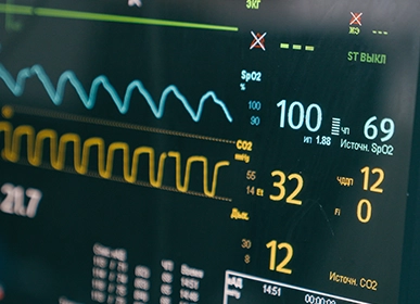 Three professional cleaners in green and red overalls working in a modern kitchen, mopping the floor, and cleaning high walls and windows.